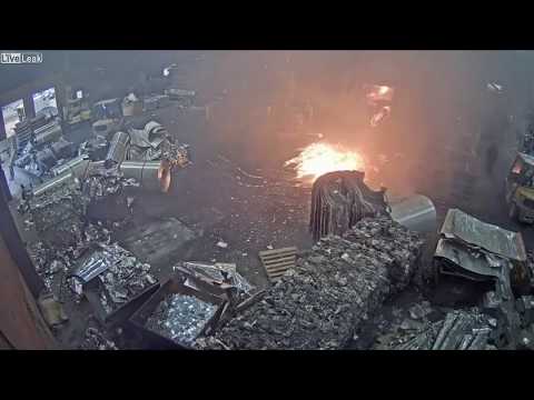 Foundry worker puts wet scrap metal in furnace